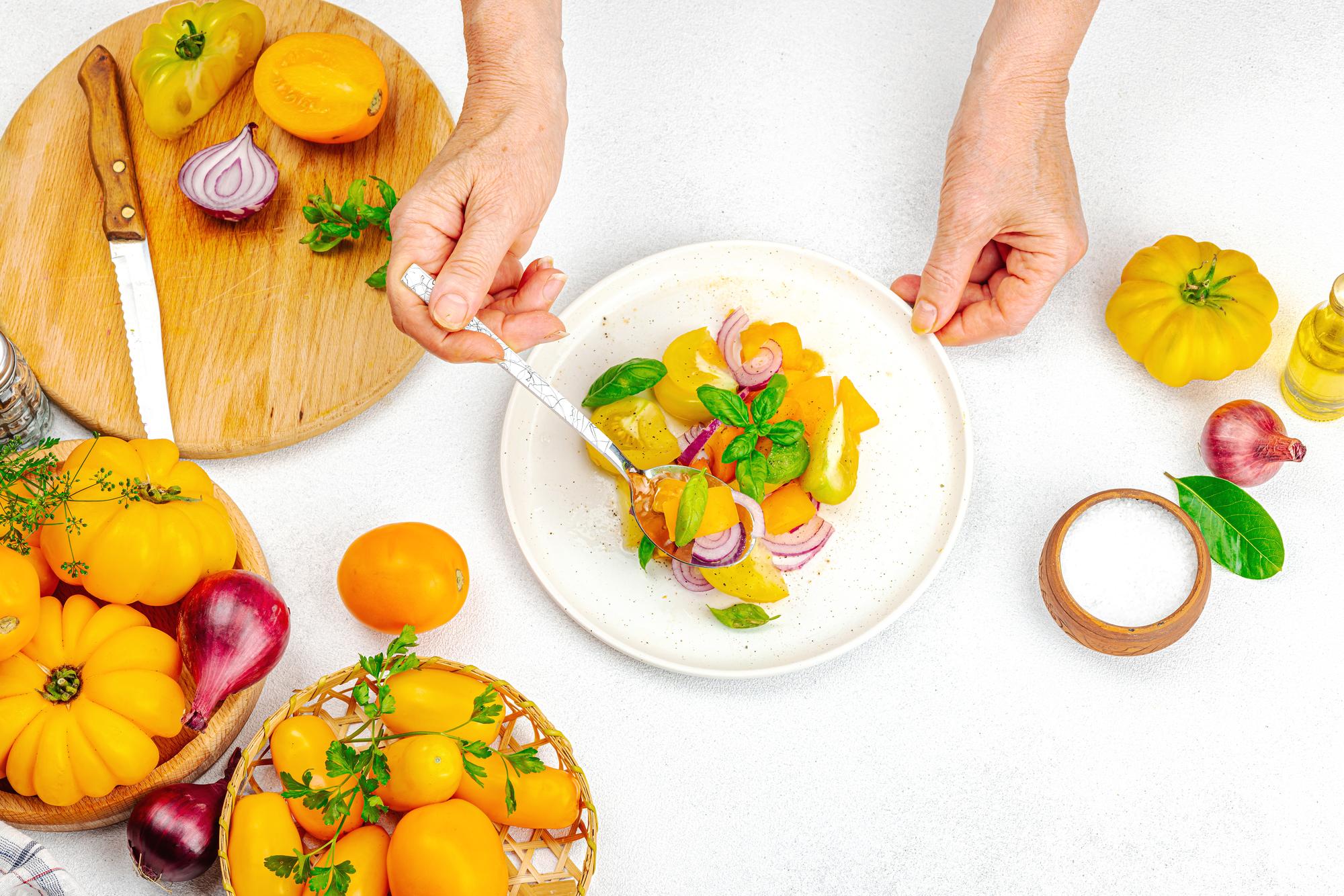 Chef arranging a plated dish on a wooden table